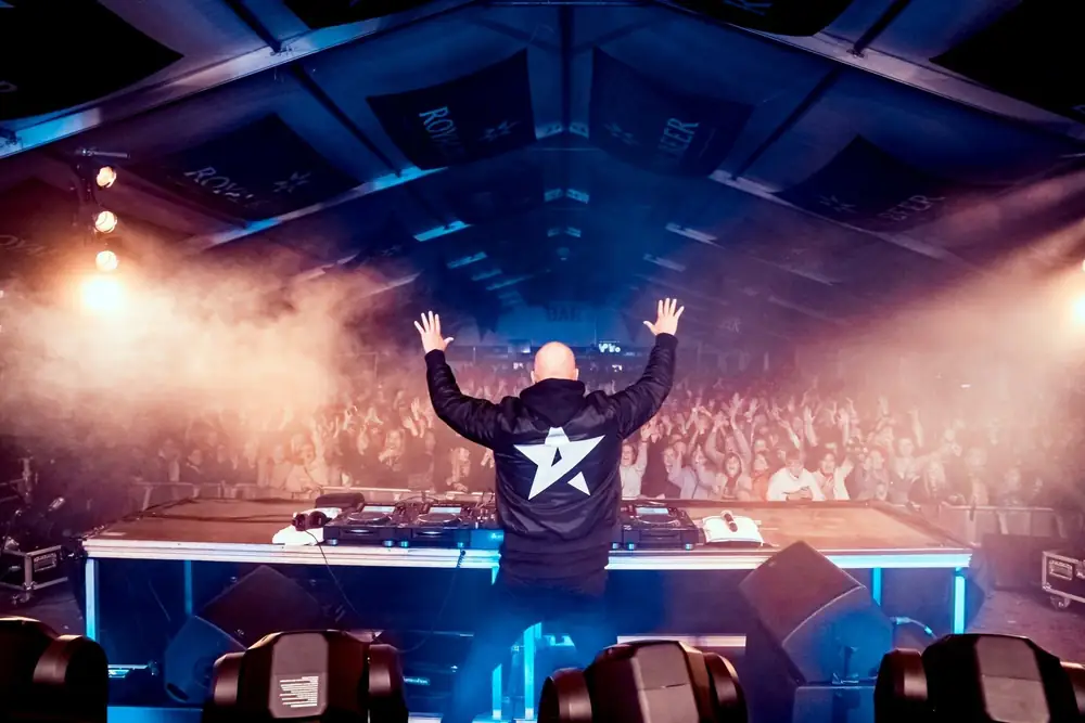DJ med armene i vejret foran publikum